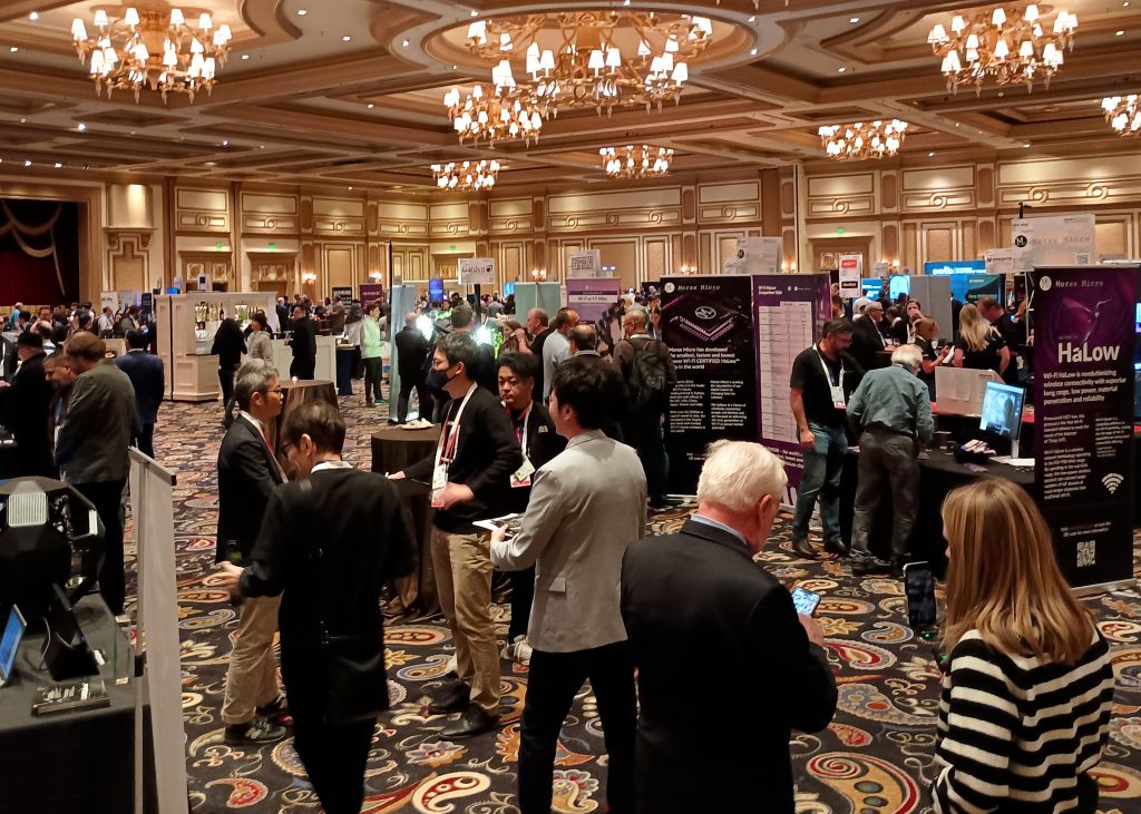 Attendees walking around company exhibit booths in a Bellagio ballroom during the ShowStoppers event.