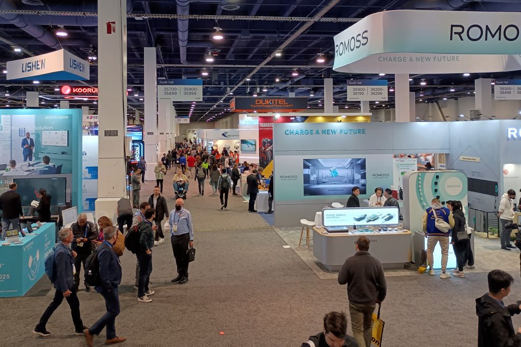 Inside the South Hall exhibit space of the Las Vegas Convention Center with attendees walking between booths.