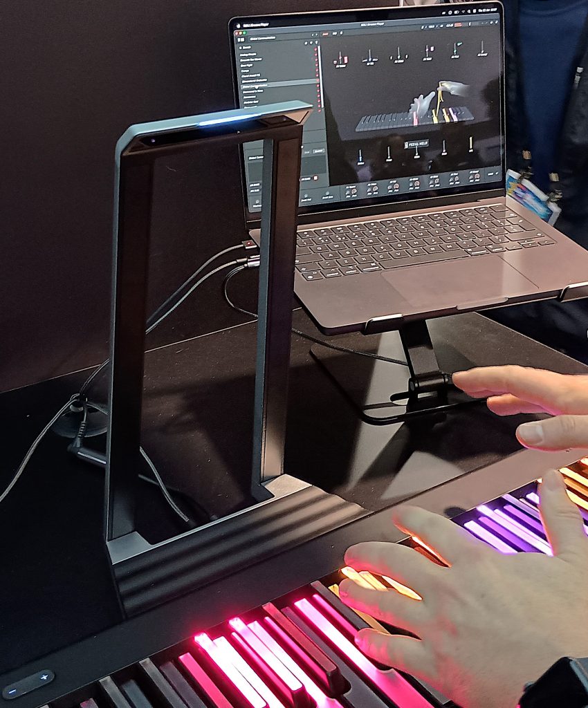 ROLI Airwave device attached to the back of a ROLI Piano with Airwave app on a laptop to the right.