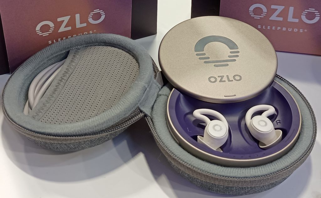 Ozlo Sleepbuds noise-masking earbuds in white, inside a grey charging case.