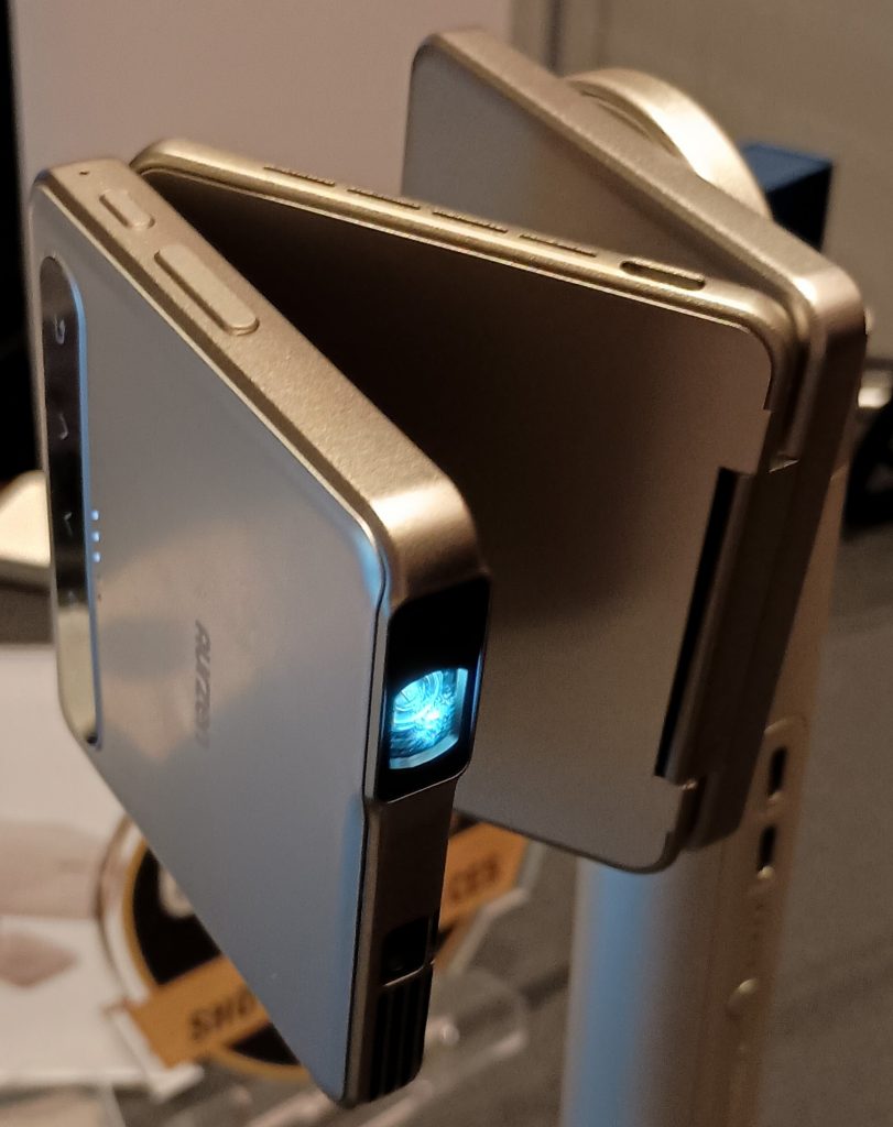 Aurzen ZIP foldable projector, mounted to a metal stand at a sideways angle and folded into a Z shape.